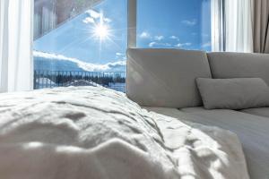 a bed in front of a window with a view at Alpine Suite Spot in Bad Mitterndorf +23 photos
