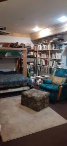 a room with a bed and a couch and bookshelves at Hungry Moose B and B in Kasilof