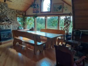 a dining room with a wooden table and a fireplace at Hungry Moose B and B in Kasilof