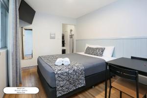 a bedroom with a bed with two towels on it at Surf Beach Motel Port in Port Macquarie +75 photos