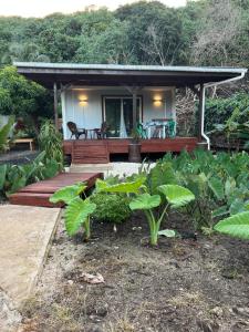 a small house with a wooden porch and plants at Kai Kabana Chill in HUH +2 photos