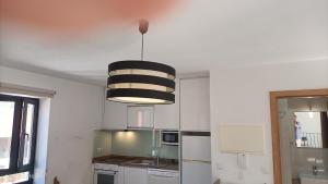 a kitchen with a black and white pendant light at Casa Bisavós de Coelhosa in Vale de Cambra +7 photos
