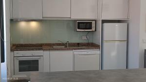 a kitchen with white appliances and a microwave at Casa Bisavós de Coelhosa in Vale de Cambra