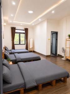 a room with four beds and a couch at La Maison DaLat Home in Ấp Kim Thạch
