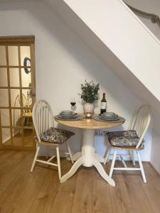 a table with two chairs and a bottle of wine at Welsh Yard Retreat in Penrith