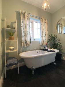 a bath tub in a bathroom with a window at Welsh Yard Retreat in Penrith +2 photos