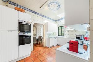 a kitchen with white cabinets and a red appliance at Quinta da Paciencia in Sintra
