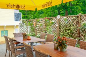 a patio with tables and chairs and an umbrella at Hotel Union Salzwedel in Salzwedel