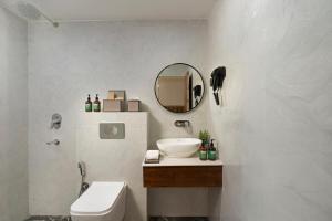 a bathroom with a sink and a toilet and a mirror at Country Inn Rishikesh at Laxman Jhula in Rishīkesh +18 photos