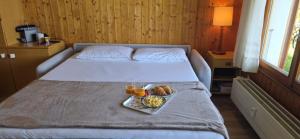 a bed with a tray of food on it at Studio Bellevue Veysonnaz in Veysonnaz