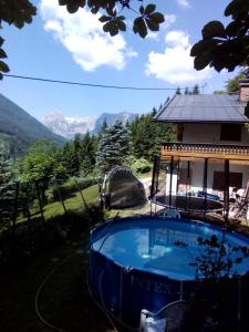 a swimming pool in front of a house with mountains in the background at Pension Unterleiten in Ramsau