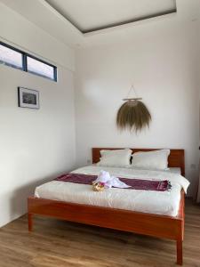 a bedroom with a bed with white walls at Svaha Ubud Villas in Siantan