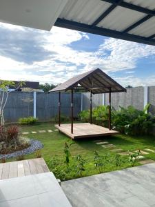 a wooden gazebo in a yard with a garden at Svaha Ubud Villas in Siantan