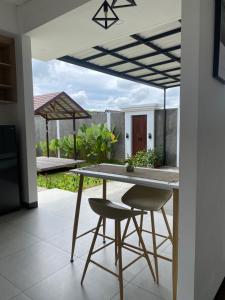 a kitchen with a table and chairs on a patio at Svaha Ubud Villas in Siantan
