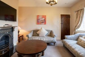 a living room with two couches and a table at Mount Pleasant Hotel Self-Catering Cottages in Doncaster