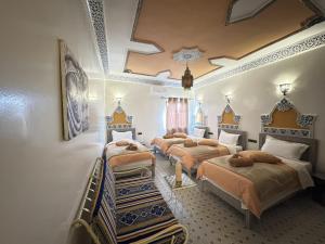 a bedroom with four beds in a room at Riad Dar Fatima in Merzouga +91 photos