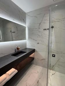 ein Badezimmer mit Waschbecken und Dusche in der Unterkunft The Tide - Hotel in Sørvågen