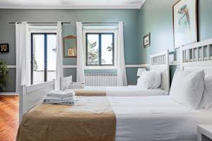 two beds in a room with blue walls and windows at Quinta da Paciencia in Sintra +29 photos