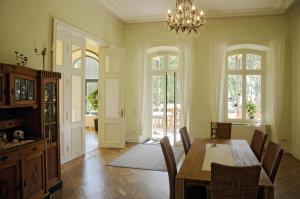a dining room with a table and chairs and a chandelier at Gutshaus Alt Vorwerk in Boddin