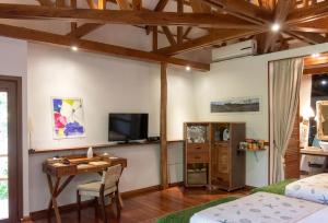 a room with a bed and a desk and a tv at Donatela Resort and Sanctuary in Panglao Island