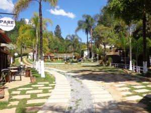 a park with palm trees and a playground at Recanto dos Carvalhos - Pousada Camping in São Lourenço