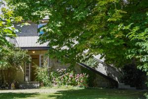 a brick house with a tree and flowers at Hotel Rose in Beauvoir
