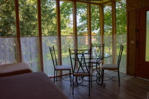 a glass table and chairs in a room with windows at Hotel Rose in Beauvoir