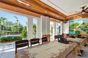 a dining room with a table and chairs and large windows at Tam Coc Valley Hideaway in Vũ Lâm