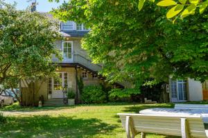 a white bench sitting in front of a house at Hotel Rose in Beauvoir +38 photos