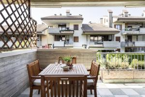 a wooden table and chairs on a balcony with buildings at Calm House in Desenzano del Garda