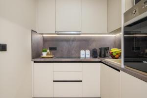 a kitchen with white cabinets and a stove top oven at MSBeach Luxury Homes - Manolis in Kos