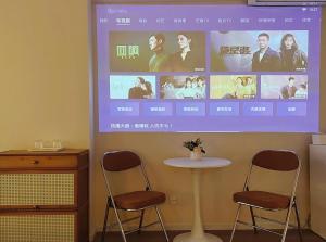 a projection screen with two chairs and a table at Tulips apartment in Chengdu