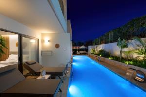 a swimming pool in the middle of a building at night at Oasis Luxury Suites in Kolymbia