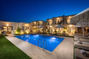 a swimming pool in the backyard of a house at night at Oasis Luxury Suites in Kolymbia
