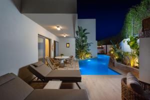 a living room with a couch and a pool at Oasis Luxury Suites in Kolymbia