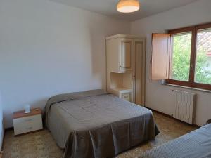 a bedroom with a bed and a cabinet and a window at Casa serusi in Copanello