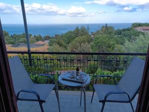 a table and chairs on a balcony with a view of the ocean at Casa serusi in Copanello