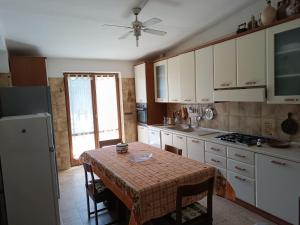 a kitchen with a table with chairs and a refrigerator at Casa serusi in Copanello