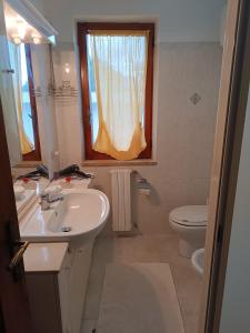 a bathroom with a sink and a toilet and a window at Casa serusi in Copanello