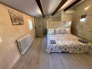 a bedroom with a bed and a radiator at La Laurisienne in Lauris +33 photos