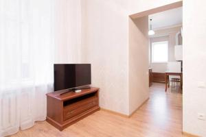 a living room with a flat screen tv on a dresser at Apartment on Deribasovskaya 18 in Odesa