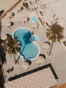 an overhead view of a pool with palm trees and chairs at Cavo Notos Beach Hotel in Kavos