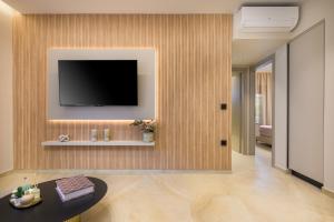 a living room with a television on a wall at MSBeach Luxury Homes - Manolis in Kos