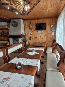 a dining room with a wooden table and a fireplace at Hotel Dudarik in Kosiv