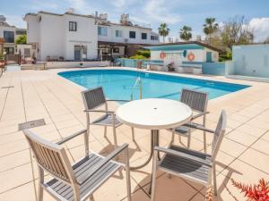 a patio with a table and chairs next to a swimming pool at The Summer Haven in Polis Chrysochous