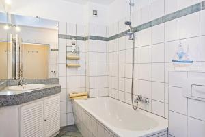 a white bathroom with a tub and a sink at Aquarius Ferienwohnung Usedom in Loddin +22 photos