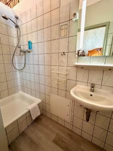 a white bathroom with a sink and a shower at Hotel Pension Bella in Berlin