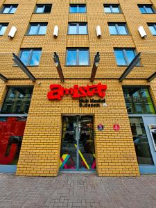 a yellow brick building with a smile sign on it at AMISTAT Hub Hostel Budapest in Budapest