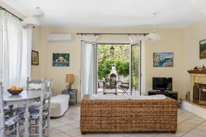 a living room with a bed and a table and a television at VK Villas in Apolpaina