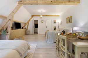 a room with white walls and wooden beams at Suite Maraval Chez L'habitant in Trélissac +24 photos